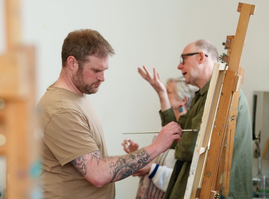 Work in progress Artist Martin Baister painting a stretched canvas on an easel.